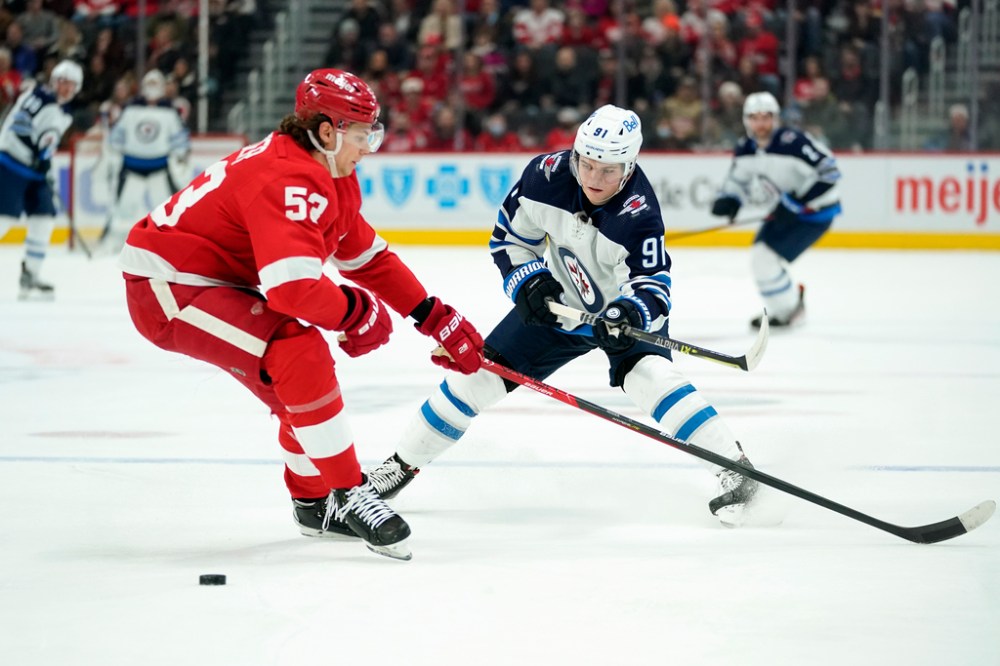 (AP Photo/Paul Sancya)
Winnipeg Jets' Cole Perfetti passes around Detroit Red Wings defenceman Moritz Seider in the first period.