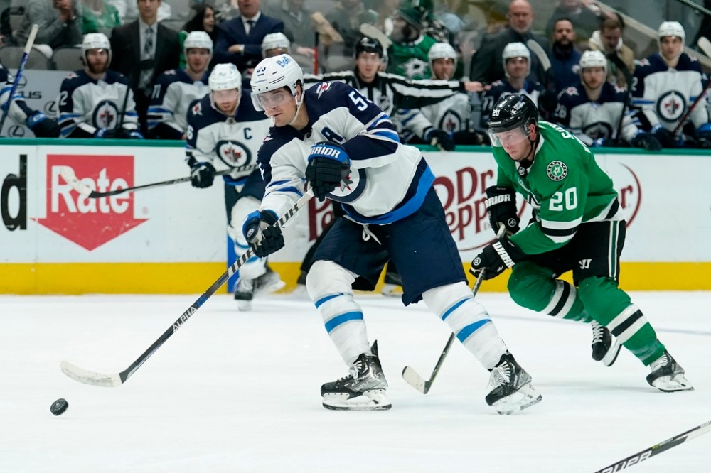 Winnipeg Jets' Mark Scheifele makes a pass as Dallas Stars' Ryan Suter follows behind in the second period. (AP Photo/Tony Gutierrez)