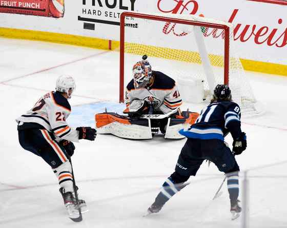 Kyle Connor scores the game-winning goal on goaltender Mike Smith during the third overtime period. (Fred Greenslade / The Canadian Press)