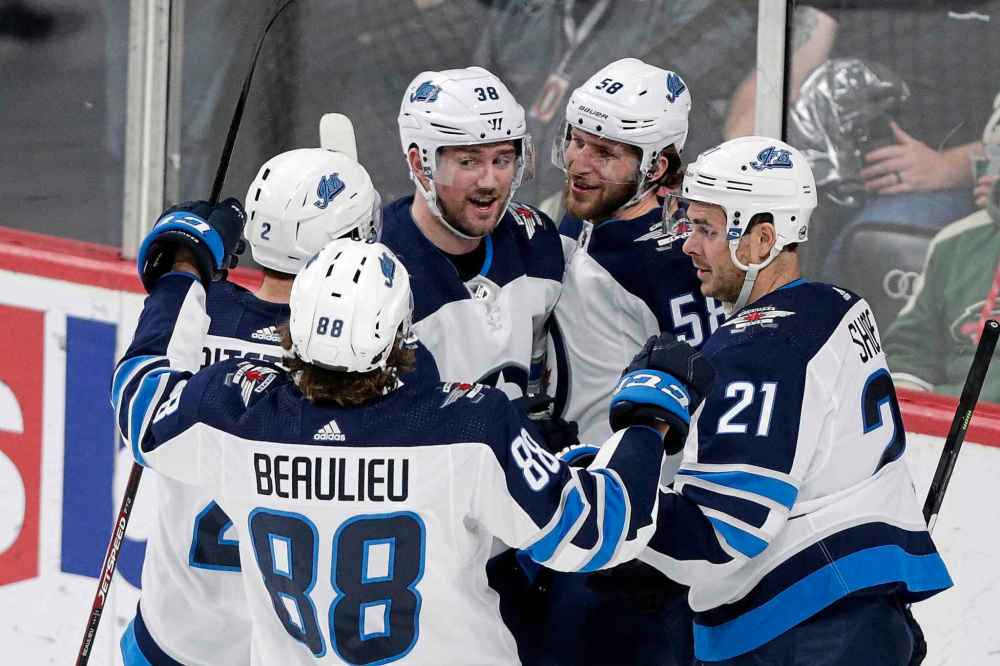 Winnipeg Jets right wing Logan Shaw (38) is congratulated by teammates Jansen Harkins (58), Nicholas Shore (21), Anthony Bitetto and Nathan Beaulieu (88) after scoring a goal on the Minnesota Wild in the third period of an NHL hockey game Saturday, Dec. 21, 2019, in St. Paul, Minn. (Andy Clayton-King / The Associated Press)