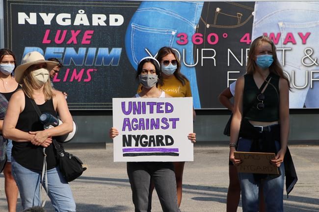People hold signs at the Time's Up Nygard protest against Canadian fashion mogul Peter Nygard in Winnipeg on Wednesday, Aug. 26, 2020. THE CANADIAN PRESS/Kelly Geraldine Malone