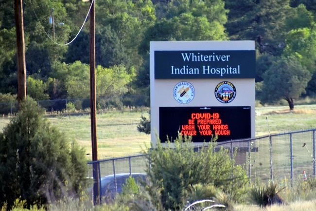 This Thursday, June 25, 2020 photo provided by C.M. Clay, shows sign at the entrance to the Whiteriver Indian Hospital in Whiteriver, Ariz., on the Fort Apache Reservation, The reservation, home to the White Mountain Apache Tribe, will be under lockdown this weekend to help slow the spread of the coronavirus. (C.M. Clay/White Mountain Apache Tribe via AP)