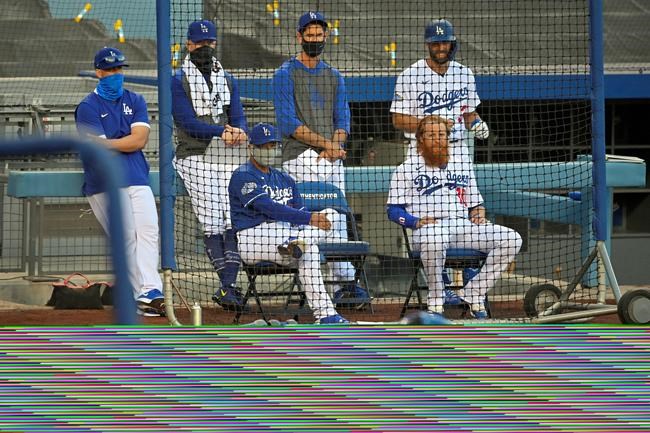 Los Angeles Dodgers manager Dave Roberts, center left, and Justin Turner, center right, watch along with other members of the team during an intrasquad baseball game Thursday, July 9, 2020, in Los Angeles. (AP Photo/Mark J. Terrill)