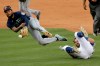 Seattle Mariners shortstop J.P. Crawford, left, tags out Los Angeles Dodgers' Chris Taylor, then throws to first to get Max Muncy for a double play during the seventh inning of a baseball game in Los Angeles, Tuesday, Aug. 18, 2020. (AP Photo/Alex Gallardo)