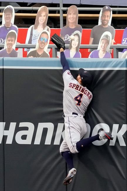 Houston Astros right fielder George Springer leaps but misses the ball for a two-run home run by Los Angeles Dodgers' Mookie Betts during the fifth inning of a baseball game in Los Angeles, Sunday, Sept. 13, 2020. (AP Photo/Alex Gallardo)