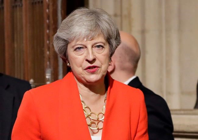 FILE - In this Monday, Oct. 14, 2019 file photo, Britain's former Prime Minister Theresa May walks through the Commons Members Lobby in Parliament, London. British Prime Minister Boris Johnson welcomed the start of a new U.K.-U.S. chapter on Wednesday Jan. 20, 2021, under incoming U.S. President Joe Biden, even as his predecessor Theresa May accused Johnson of “abandoning” the U.K.’s moral leadership in the world during the tumultuous Trump era. (AP Photo/Kirsty Wigglesworth, pool, file)