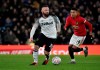 FILE - In this Thursday, March 5, 2020 file photo, Derby's Wayne Rooney, left, and Manchester United's Jesse Lindgard run for the ball during the FA Cup fifth round soccer match between Derby County and Manchester United at Pride Park in Derby, England. A member of Abu Dhabi’s royal family has agreed to a deal to buy English soccer club Derby, the second-division team where Wayne Rooney plays. Derby said Friday Nov. 6, 2020 a deal “in principle” has been reached with Derventio Holdings Limited, which is controlled by Sheikh Khaled Zayed Bin Saquer Zayed Al Nayhan. He is the cousin of the owner of Manchester City, Sheikh Mansour. (AP Photo/Rui Vieira, File)