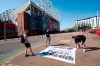 FILE - In this Monday, April 19, 2021 file photo, supporters place a protest banner outside Manchester United's Old Trafford Stadium, Manchester, England, opposing the formation of the European Super League. Manchester United tried to reassure skeptical fans that it won't revive plans for the Super League, though many supporters still expressed outrage on Friday April 30, 2021. (AP Photo/Jon Super, File)