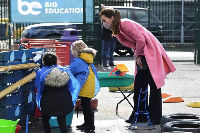 Britain's Kate, Duchess of Cambridge talks with children in the water area of the playground during a visit with Prince William to School21, a school in east London, Thursday March 11, 2021. (Justin Tallis/Pool via AP)