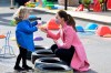 Britain's Kate, Duchess of Cambridge talks with a child in the water area of the playground during a visit with Prince William to School21, a school in east London, Thursday March 11, 2021. (Justin Tallis/Pool via AP)