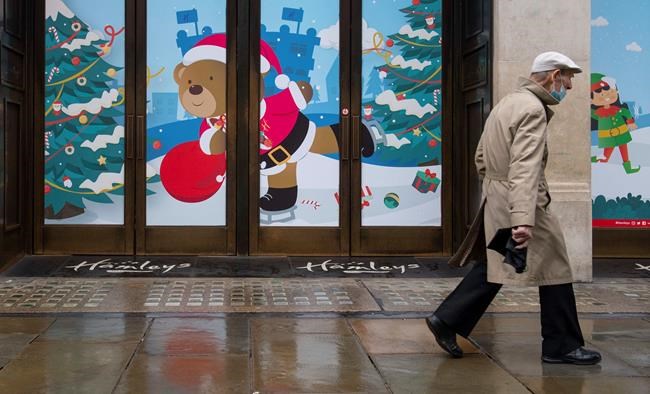 A man walks past closed shops on Regent Street, in London on Monday Dec. 21, 2020. Millions of people in England have learned they must cancel their Christmas get-togethers and holiday shopping trips. British Prime Minister Boris Johnson said Saturday that holiday gatherings can’t go ahead and non-essential shops must close in London and much of southern England. (Dominic Lipinski/PA via AP)