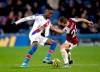 Crystal Palace's Wilfried Zaha, left, and Burnley's Phil Bardsley battle for the ball during the English Premier League soccer match at Turf Moor, Burnley, England, Saturday Nov. 30, 2019. (Martin Rickett/PA via AP)