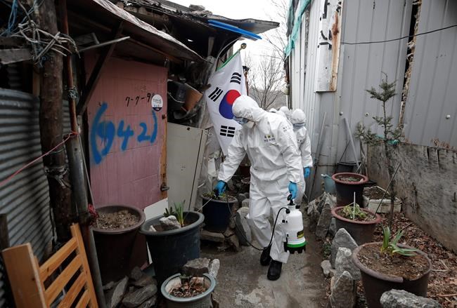 Soldiers wearing protective gear spray disinfectant in neighborhood alleyways as a precaution against the new coronavirus in Seoul, South Korea, Tuesday, March 3, 2020. (AP Photo/Lee Jin-man)