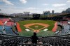 A TV cameraman films in the empty stadium as a part of precaution against the new coronavirus during the pre-season baseball game between Doosan Bears and LG Twins in Seoul, South Korea, Tuesday, April 21, 2020. South Korea's professional baseball league has decided to begin its new season on May 5, initially without fans, following a postponement over the coronavirus. (AP Photo/Lee Jin-man)