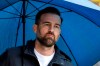 FILE - In this Saturday, April 27, 2019 file photo, Christoph Metzelder watches under an umbrella prior the German Bundesliga soccer match between Borussia Dortmund and FC Schalke 04 in Dortmund, Germany. Former Germany defender Christoph Metzelder will stand trial on charges of possession and distribution of child pornography on April 29, 2021. He faces 29 charges of attempted distribution of child pornography to another person, and one charge of the possession of child and youth pornography. (AP Photo/Martin Meissner, file)