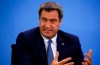 Bavarian State Prime Minister Markus Soeder addresses the media following a meeting with leaders of the 16 federal states to discuss the country's response following the spread of the coronavirus, at the Chancellery in Berlin, Thursday, Aug. 27, 2020. In an effort to harmonize different coronavirus measures across the country, Germany will implement a nationwide fine for people not wearing face masks and also ban mass events until the end of the year, Chancellor Angela Merkel said Thursday. (Michele Tantussi/Pool Photo via AP)