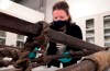 A conservator surveys an eleven-foot wooden sledge used on Anglo-Irish explorer Ernest Shackleton’s British Antarctic Expedition, on a table at Prince Philip Maritime Collections Centre, London, Tuesday, Dec. 15, 2020. A sledge and flag once used in a famed 1900s expedition to the South Pole have been bought by a British government-funded body, preventing the treasured artefacts leaving the country to an overseas buyer. The National Heritage Memorial Fund, a government-funded body founded in 1980, said Wednesday it had provided 204,000 British pounds to help purchase the two items, which will be donated to two English museums. (AP Photo/James Brooks)