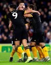 Wolverhampton Wanderers' Diogo Jota, center obscured, celebrates scoring his side's second goal of the game with teammates during their English Premier League soccer match against Brighton and Hove Albion at the Amex Stadium, Brighton, England, Sunday, Dec. 8, 2019. (Gareth Fuller/PA via AP)