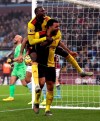 Watford's Troy Deeney celebrates scoring his side's first goal of the game against Aston Villa, with Abdoulaye Doucoure, left, during their English Premier League soccer match at Villa Park in Birmingham, England, Tuesday Jan. 21, 2020. (David Davies/PA via AP)