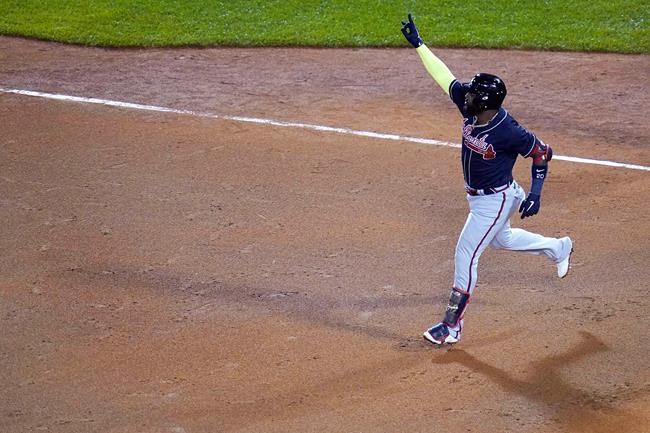 Atlanta Braves designated hitter Marcell Ozuna raises his arm as he rounds the bases on his solo home run in the seventh inning of a baseball game against the Boston Red Sox, Wednesday Sept. 2, 2020, in Boston. (AP Photo/Charles Krupa)