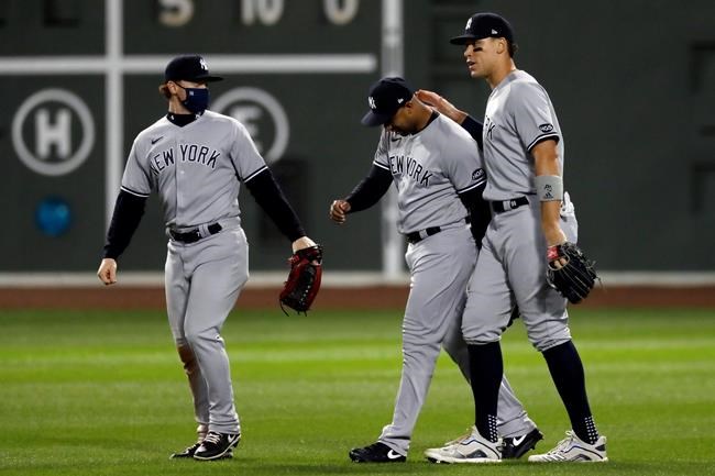 New York Yankees' Clint Frazier, left, Aaron Hicks, center, and Aaron Judge celebrate after the Yankees defeated the Boston Red Sox in the 12th inning of a baseball game, early Saturday, Sept. 19, 2020, in Boston. (AP Photo/Michael Dwyer)