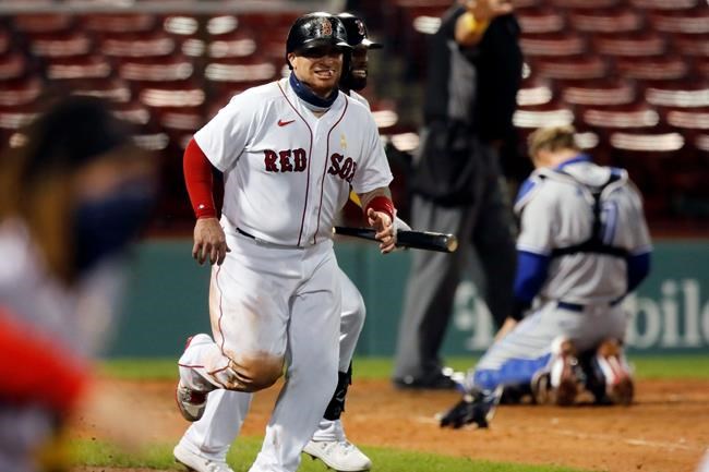 Boston Red Sox's Christian Vazquez, left, celebrates after scoring the winning run, while Toronto Blue Jays' Caleb Joseph kneels at home plate during the ninth inning of a baseball game Saturday, Sept. 5, 2020, in Boston. (AP Photo/Michael Dwyer)