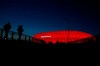 Jogger make their way after the sun sets at the 'Allianz Arena' soccer stadium in Munich, Germany, Monday, March 16, 2020. (AP Photo/Matthias Schrader)