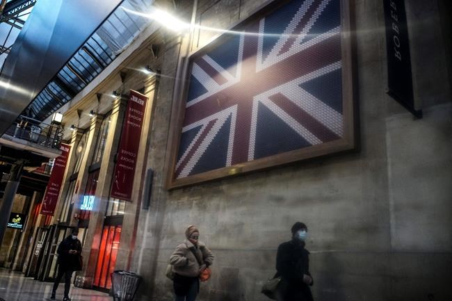 Passengers wearing face mask walk next to the Eurostar Terminal at Gare du Nord train station in Paris, Monday Dec. 21, 2020, next to a Eurostar train. France is banning all travel from the U.K. for 48 hours in an attempt to make sure that a new strain of the coronavirus in Britain doesn't reach its shores. (AP Photo/Lewis Joly)