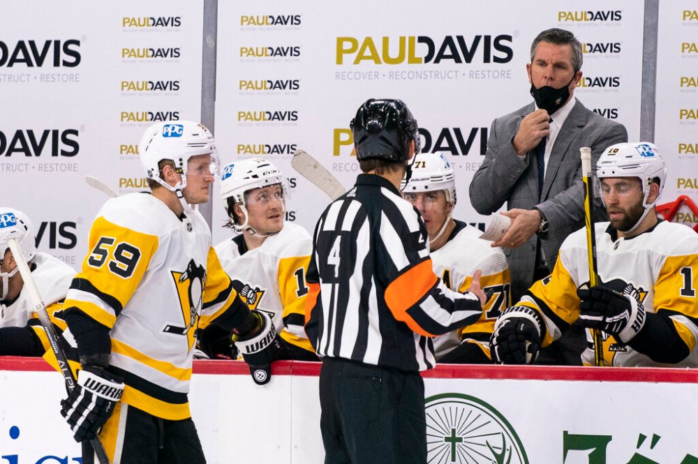 Pittsburgh Penguins head coach Mike Sullivan, right, lowers his mask to talk to referee Wes McCauley during a game against the Philadelphia Flyers. (AP Photo/Chris Szagola, File)