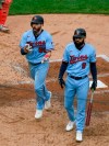 Minnesota Twins's Jake Cave, left, celebrates after scoring on a balk by Cincinnati Reds pitcher Sonny Gray who was throwing to Twins' Marwin Gonzalez during the fifth inning of a baseball game Sunday, Sept. 27, 2020, in Minneapolis. (AP Photo/Craig Lassig)