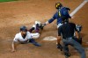 Minnesota Twins' Byron Buxton, left, scores the winning run on a single by Jorge Polanco off Milwaukee Brewers pitcher David Phelps during the 12th inning of a baseball game Tuesday, Aug. 18, 2020, in Minneapolis. Catching is Brewers' Manny Pina. The Twins won 4-3. (AP Photo/Jim Mone)