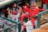 Cincinnati Reds' Mike Moustakas (9) is greeted in the dugout after his solo home run off Minnesota Twins pitcher Edwar Colina during the ninth inning of a baseball game Friday, Sept. 25, 2020, in Minneapolis. (AP Photo/Jim Mone)
