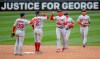 Boston Red Sox celebrate a 4-2 win over the Minnesota Twins in a baseball game Tuesday, April 13, 2021, at Target Field in Minneapolis. In the background is a sign about George Floyd. (Elizabeth Flores/Star Tribune via AP)
