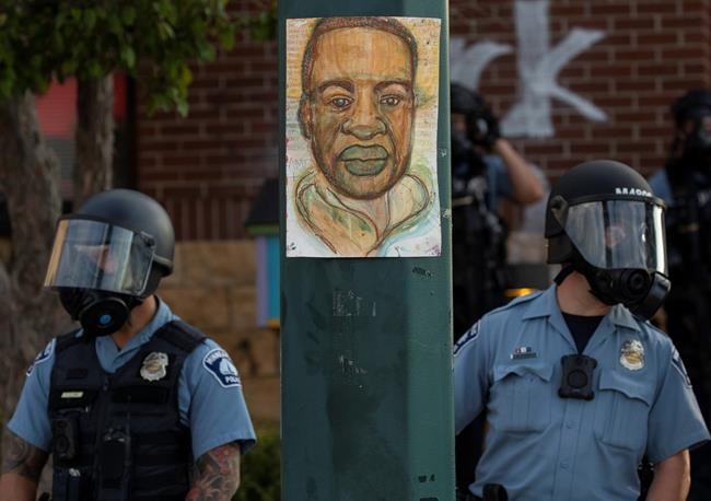Minnesota police stand outside the department's 3rd Precinct on Wednesday, May 27, 2020, in Minneapolis. The mayor of Minneapolis called Wednesday for criminal charges against the white police officer seen on video kneeling against the neck of Floyd George, a handcuffed black man who complained that he could not breathe and died in police custody. (Carlos Gonzalez/Star Tribune via AP)