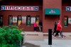 People walk outside Busch Stadium after the start of a baseball game between the St. Louis Cardinals and the New York Mets was delayed because of rain Tuesday, May 4, 2021, in St. Louis. (AP Photo/Jeff Roberson)