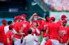St. Louis Cardinals' Kolten Wong throws a face mask in the air as he celebrates with teammates after defeating the Milwaukee Brewers in a baseball game to earn a playoff birth Sunday, Sept. 27, 2020, in St. Louis. (AP Photo/Jeff Roberson)