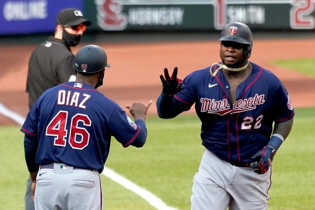 Minnesota Twins' Miguel Sano (22) is congratulated by third base coach Tony Diaz (46) while rounding the bases after hitting a two-run home run during the seventh inning in the first game of a baseball doubleheader against the St. Louis Cardinals Tuesday, Sept. 8, 2020, in St. Louis. (AP Photo/Jeff Roberson)