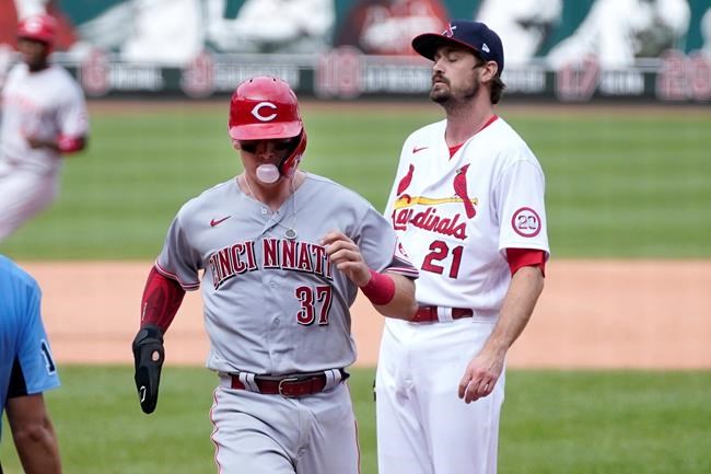 Cincinnati Reds' Tyler Stephenson, left, scores on a wild pitch by St. Louis Cardinals relief pitcher Andrew Miller, right, during the seventh inning of a baseball game Sunday, Sept. 13, 2020, in St. Louis. (AP Photo/Jeff Roberson)