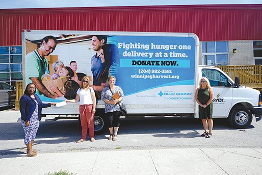 MANITOBA BLUE CROSS CHIEF OPERATING OFFICER BRENDA SLIKKER (SECOND FROM LEFT) PRESENTS A DONATION TO WINNIPEG HARVEST CHIEF EXECUTIVE OFFICER KEREN TAYLOR-HUGHES (LEFT).