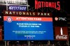 The scoreboard displays a message to fans during a stoppage in play due to an incident near the ballpark in the sixth the inning of a baseball game between the Washington Nationals and the San Diego Padres, Saturday, July 17, 2021, in Washington. (AP Photo/Nick Wass)