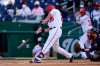 Washington Nationals' Jonathan Lucroy doubles in front of Atlanta Braves catcher Travis d'Arnaud in the second inning of an opening day baseball game at Nationals Park, Tuesday, April 6, 2021, in Washington. Hernan Perez and Andrew Stevenson scored on the play. (AP Photo/Alex Brandon)