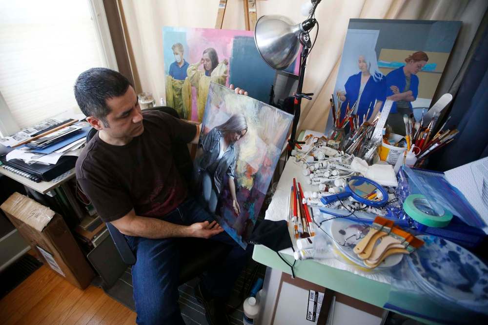 JOHN WOODS / WINNIPEG FREE PRESS
Roberts in his home studio with portraits he has painted of his health-care co-workers.