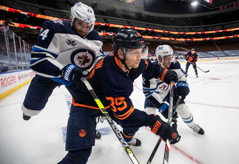 Jason Franson / The Canadian Press
Derek Forbort (left) and Dylan DeMelo mix it up with the Oilers Alex Chiasson Wednesday night.