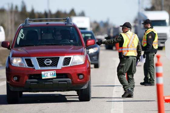 Conservation officers stop vehicles on the Trans Canada at the Manitoba-Ontario border in March. Ontario Provincial Police say they are turning away up to 30 Manitobans a day that are trying to enter Ontario. THE CANADIAN PRESS FILES/John Woods