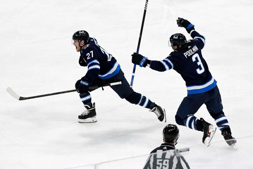 Fred Greenslade / The Canadian Press
Nikolaj Ehlers (left) celebrates with Tucker Poolman Sunday after scoring the overtime winner, his second goal of the game, against the Oilers in his first game back after an injury.
