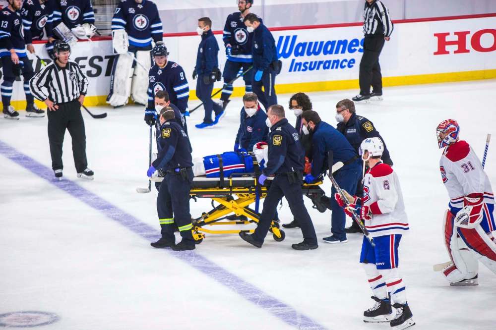 MIKAELA MACKENZIE / WINNIPEG FREE PRESS
Paramedics take Montreal's Jake Evans off the ice on a stretcher after he was checked by Mark Scheifele late in Wednesday night's game.