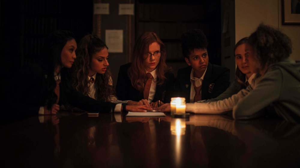 >Ask the planchette which of these women isn’t long for this world?:Stephanie Sy (from left), Inanna Sarkis, Madisen Beaty, Djouliet Amara, Suki Waterhouse and Ella-Rae Smith in the locally lensed Seance. (RLJE Films and Shudder)