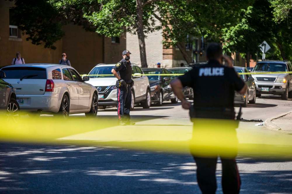 Police investigate the scene of a shooting at Young and Balmoral streets in West Broadway Monday. Mikaela Mackenize / Winnipeg Free Press