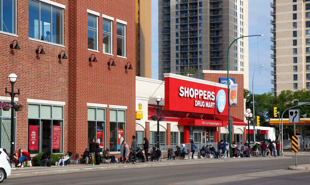 MIKE DEAL / WINNIPEG FREE PRESS
Hundreds of people line up early Monday morning in the hopes of getting a Pfizer vaccine at the Shoppers Drug Mart in Osborne Village.