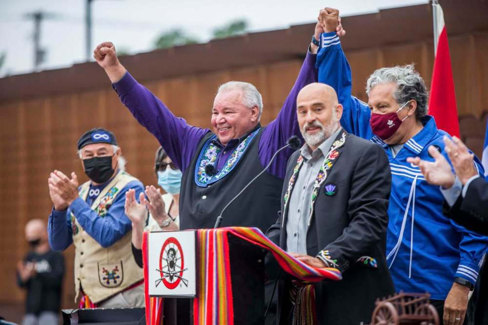 MIKAELA MACKENZIE / WINNIPEG FREE PRESS
Chartrand (centre) and Minister of Northern Affairs Dan Vandal hold arms up in victory at the signing ceremony as Clement Chartier (left), Leah LaPlante, and Will Goodon look on.